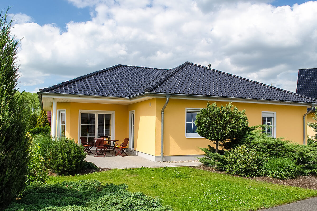 Bungalow von SYSTEM MASSIVHAUS mit Walmdach