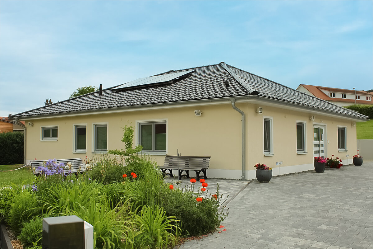 Bungalow von SYSTEM MASSIVHAUS mit Walmdach