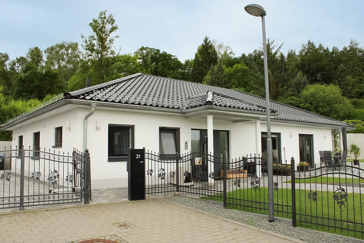 Bungalow von SYSTEM MASSIVHAUS mit Walmdach