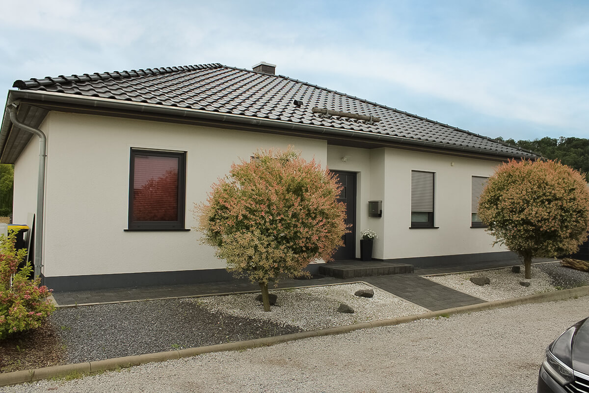 Bungalow von SYSTEM MASSIVHAUS mit Walmdach